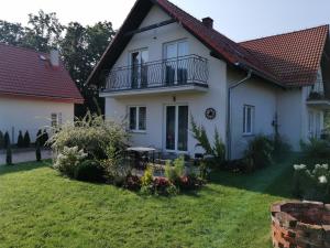 Biały dom z balkonem i dziedzińcem w obiekcie Apartament Mysłakowice w mieście Mysłakowice