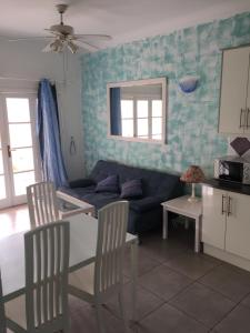 een woonkamer met een bank en een tafel en stoelen bij Apartament Yucca Fanabe in Adeje