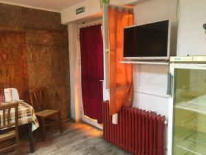 un soggiorno con TV e radiatore rosso di Casa Roz a Cluj-Napoca