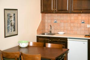 Mylos Hotel Apartments في بلاتانياس: مطبخ مع طاولة وكراسي ومغسلة