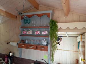 a kitchen with a shelf with glasses and utensils at Cabin Dan in Great Malvern +40 photos