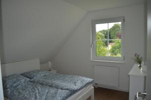a bedroom with a bed and a window at Ferienhaus Mück in Ankershagen