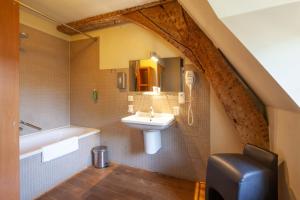 un bagno con un lavandino, una vasca da bagno e un lavandino di Hotel The Lodge Heverlee a Lovanio