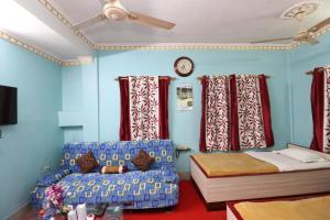 1 dormitorio con cama, sofá y reloj en Hotel Airways en Calcuta