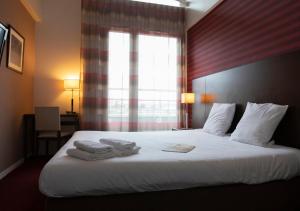 une chambre d'hôtel avec un lit et des serviettes. dans l'établissement The Originals Residence KOSY appart'hôtels - Les Cèdres, à Grenoble