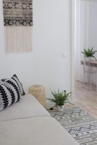 a white bedroom with a bed and a chair at Lechner4 Residence in Szeged