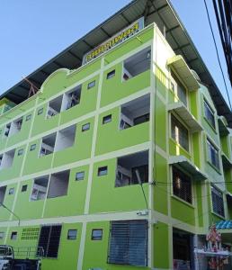 un edificio verde lima con balcones y ventanas en Natcha Place TU Rangsit en Ban Bang Khan
