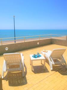 two chairs and a table on a balcony with the ocean at Gambusia in Scoglitti
