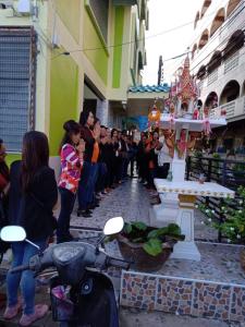 a group of people standing around a shrine in a street at Natcha Place TU Rangsit in Ban Bang Khan