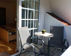 - une petite table et 2 chaises sur une terrasse couverte dans l'établissement Pension & Ferienhof Glüß, à Lünzen