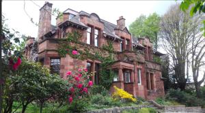 an old brick house with flowers in front of it at Netherbrae in Edinburgh