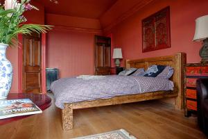 ein Schlafzimmer mit einem Bett und einer Vase aus Blumen in der Unterkunft Netherbrae in Edinburgh