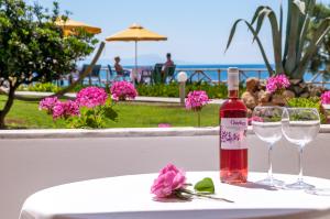 una bottiglia di vino seduta su un tavolo con due bicchieri di Alkionis Beach Hotel Apartments a Sfakaki