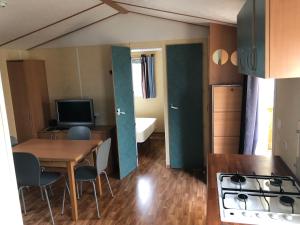 a small apartment with a table and chairs and a kitchen at Mobil-home 5 personnes proche de la plage in Berck-sur-Mer