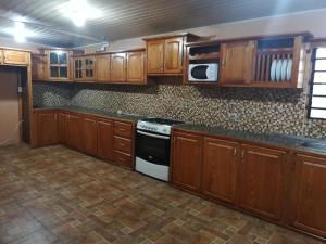 a kitchen with wooden cabinets and a stove at Preferred Place in Trincity 