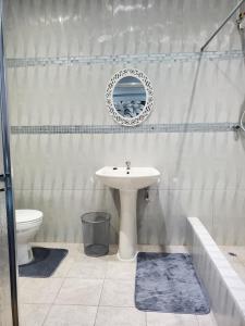 a bathroom with a sink and a toilet and a mirror at Preferred Place in Trincity 