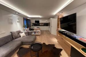 uma sala de estar com um sofá e uma televisão de ecrã plano em Modernes & Erholsames Leben em Mötz