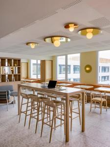 um quarto com uma mesa com cadeiras e um computador portátil em OKKO Hotels Nice Aéroport em Nice