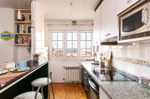 a kitchen with white cabinets and a counter top at Duplex 21, alojamiento cerca de la playa con WIFI in Gijón