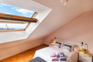 een slaapkamer met een bed en een groot raam bij Duplex 21, alojamiento cerca de la playa con WIFI in Gijón