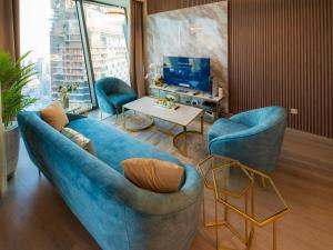 a living room with a blue couch and two chairs at FIRST CLASS 3BR with full BURJ KHALIFA and FOUNTAIN VIEW in Dubai