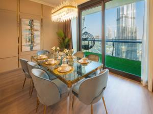 a dining room with a table and chairs and a large window at FIRST CLASS 3BR with full BURJ KHALIFA and FOUNTAIN VIEW in Dubai