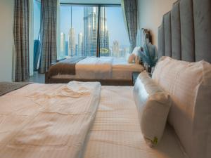 Una cama o camas en una habitación de FIRST CLASS 3BR with full BURJ KHALIFA and FOUNTAIN VIEW