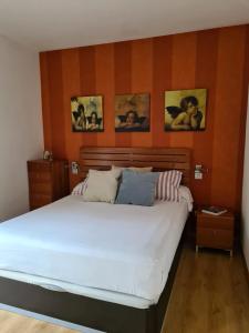 een slaapkamer met een groot wit bed met drie foto's aan de muur bij Dos Torres Edificio de los Arcos 5 - Plaza de Parking Incluida in Zaragoza