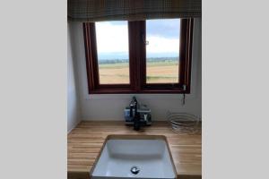 um lavatório num quarto com uma janela em Idyllic Shepherds Hut, Bylaugh, in private wildflower meadow em Swanton Morley