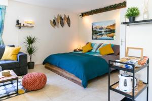 een slaapkamer met een blauw bed en een bank bij Spirit Apartments - Studio 1 - Küche - Parkplatz in Engelberg