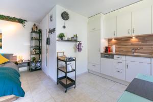 una cocina con armarios blancos y fregadero en Spirit Apartments - Studio 1 - Küche - Parkplatz en Engelberg