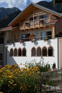 a house with windows and flowers in front of it at B&B Fontanella in San Lorenzo in Banale