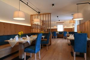 una sala da pranzo con tavoli e sedie blu di B&B Fontanella a San Lorenzo in Banale