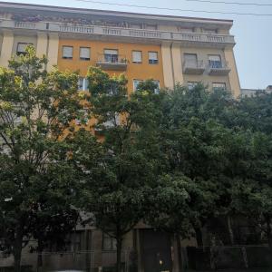 a yellow building with trees in front of it at GREEN RIBBON in Milan