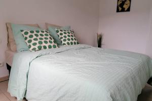 ein Bett mit einer weißen Bettdecke und Kissen darauf in der Unterkunft T2 entier - Hyper centre - Cosy home in Grenade-sur-Garonne