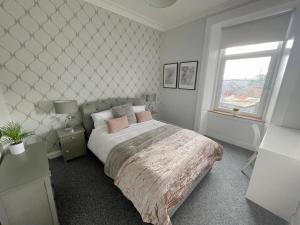 sypialnia z łóżkiem i oknem w obiekcie The Portside Apartment w mieście Greenock