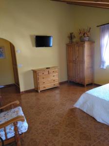 1 dormitorio con 1 cama y TV en la pared en El Mirador de Cercedilla - Nueva Apertura en Cercedilla