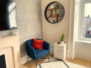 a blue chair in a living room with a mirror at The Portside Apartment in Greenock