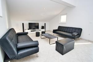 a living room with two black couches and a tv at Apartman ZORKA in Radovin
