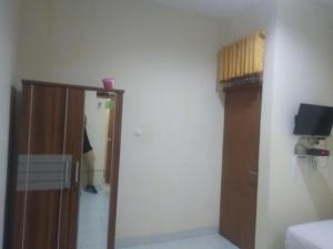 een kamer met een deur en een persoon die in een kamer staat bij Modern Indekos Cilegon Syariah RedPartner in Grogol