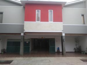 een rood-wit gebouw met een binnenplaats bij Modern Indekos Cilegon Syariah RedPartner in Grogol