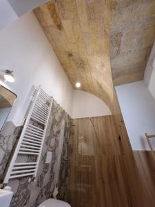 a bathroom with a toilet and a wooden ceiling at B&B Novecento Italiano in Altamura +91 photos