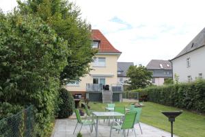 a patio with a table and chairs in a yard at Pension Alscher Garni in Goslar