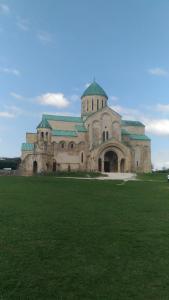 a large building with a green field in front of it at host N1 in Kutaisi