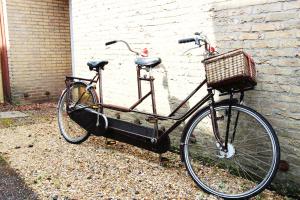 a bike with a basket parked next to a brick wall at Valhalla in Egmond-Binnen