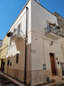 a white building with two balconies on a street at B&B Novecento Italiano in Altamura