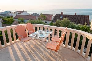 a table and chairs on a balcony with the ocean at House Koloc in Bol