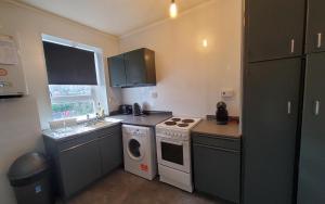 a small kitchen with a stove and a sink at Aberdeen 4 Bedroom Apartment By Sensational Stay Short Lets & Serviced Accommodation, Bedford Avenue in Aberdeen