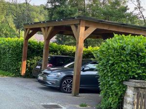 a car parked under a wooden pavilion in a driveway at Les Arpents Verts in Momignies +12 photos