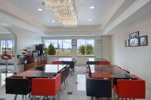 a restaurant with tables and chairs and a chandelier at Ramada by Wyndham South Waco in Hewitt